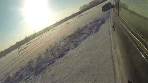 Pista de carro preto em uma estrada nevada — Vídeo de Stock