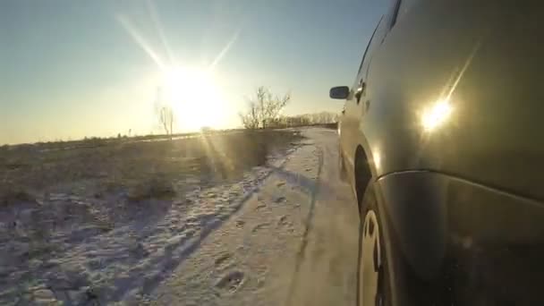 Чорний автомобіль катається на сніговій дорозі — стокове відео