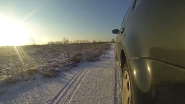 Coche negro conduciendo por carretera cubierta de nieve — Vídeos de Stock