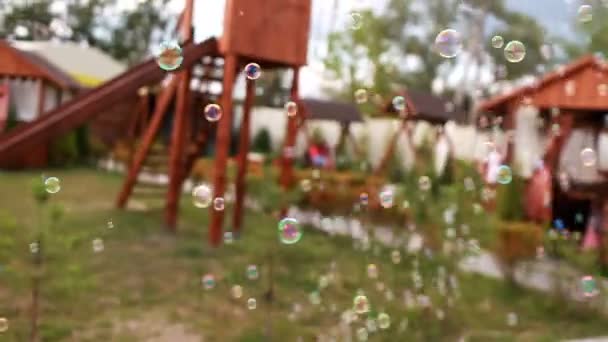 Bolhas de sabão no fundo do parque infantil — Vídeo de Stock