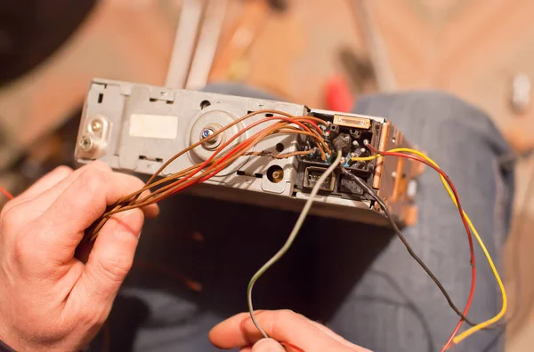 Szakosodott javítása a régi autó rádió cassetter jegyző a térd — Stock Fotó