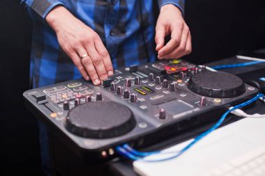 DJ gece kulübünde konsolda müzik karıştırıyor.