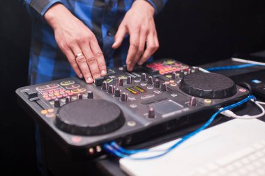 DJ gece kulübünde konsolda müzik karıştırıyor.
