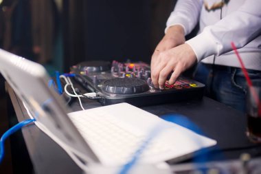 DJ gece kulübünde konsolda müzik karıştırıyor.