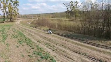 Bir kız bir ara sokakta ağaçları ile üzerinde bir motosiklet sürme
