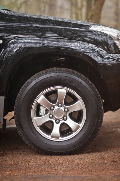 Close-up photo wheel of an SUV that stands in the woods — Stock Photo, Image