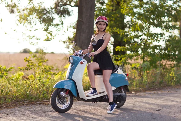 Девушка на скутере по проселочной дороге — стоковое фото