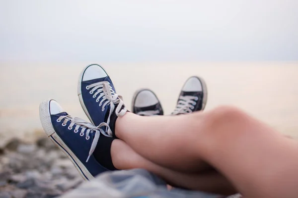 Die Beine eines Mannes und eines Mädchens am Abend am Strand — Stockfoto