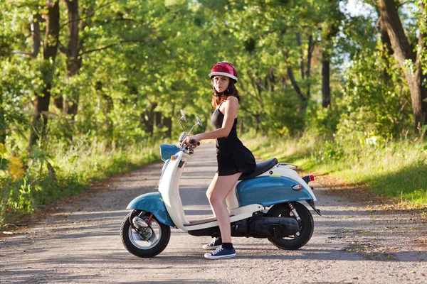 Bir scooter üzerinde köy yolunda bir kızla