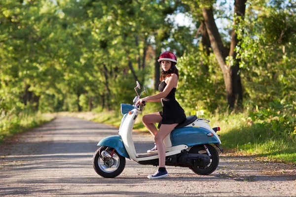 Bir scooter üzerinde köy yolunda bir kızla