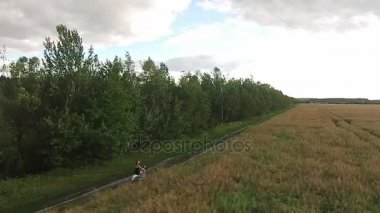 Bir kız bir ülke yolda bir scooter sürme