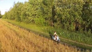 Bir kız bir ülke yolda bir scooter sürme