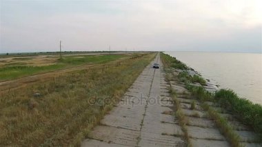 Kamerayı uçağı denize yakın dolgu boyunca rides araba izler