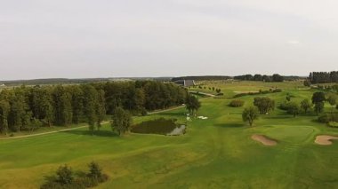 Bir dron yeşil bir golf sahası üzerinde uçar