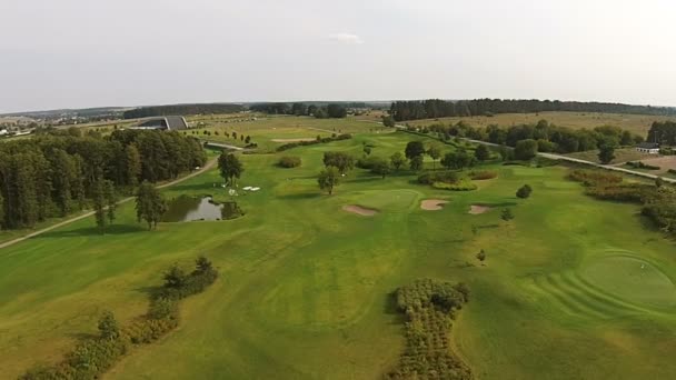 Eine Drohne fliegt über einen grünen Golfplatz — Stockvideo