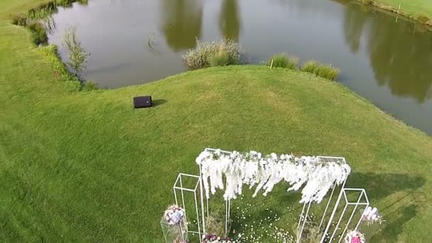 Un drone survole un parcours de golf vert avec arche de mariage 