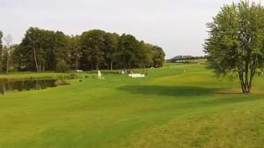 Bir dron yeşil bir golf sahası üzerinde uçar. Düğün hazırlıkları
