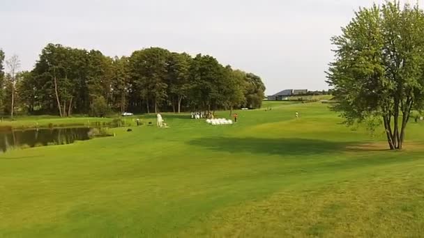 Eine Drohne fliegt über einen grünen Golfplatz. Hochzeitsvorbereitungen — Stockvideo