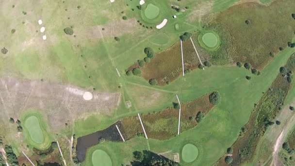 A drone flies over a green golf course with lake — Stock Video