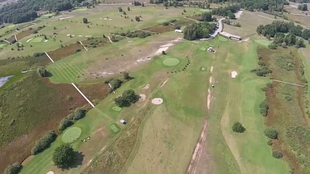 En drönare flyger över en grön golfbana med bröllop arch — Stockvideo