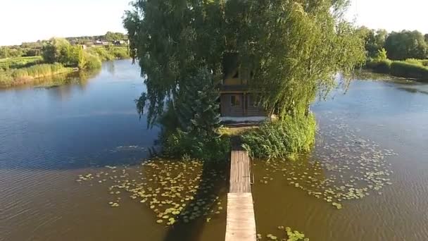 Жилой дом с деревьями в центре озера — стоковое видео