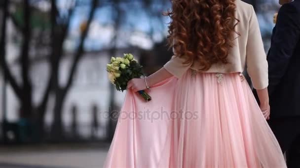 A menyasszony megy egy rózsaszín ruhát, és egy-egy csokor sárga virágok — Stock videók