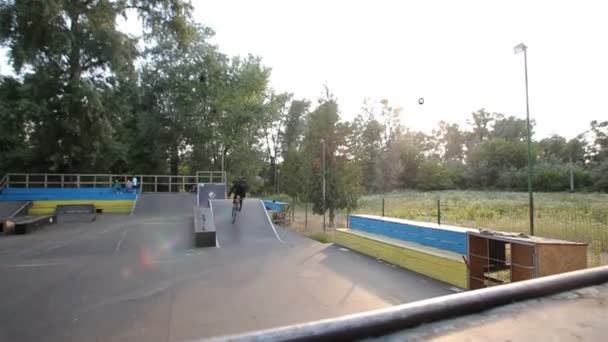 Kiev, Ukraina - juni 16, 2016: En kille skridsko i en skateboardpark på cykel — Stockvideo