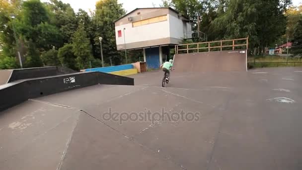 Kiev, Ukrajna - 2016. június 16.: A srác skate skate park egy kerékpáros — Stock videók