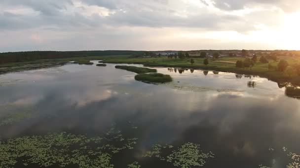 A légi felvétel a tó naplementekor — Stock videók