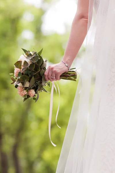 Hands of bride holding a bouquet of roses — Stock Photo, Image