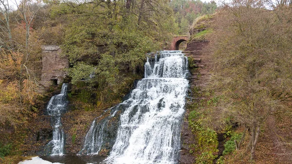 Waterfall in the forest from the trees covered with yellow foliage — Stock Photo, Image