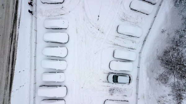 Aerila view of snow-covered cars stand in the parking lot on a winter day — Stock Photo, Image