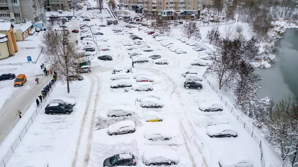 Aerila view of snow-covered cars stand in the parking lot on a winter day — Stock Photo, Image