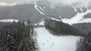 Genç bir adam Alpin yamaç aşağı bir snowboard binme