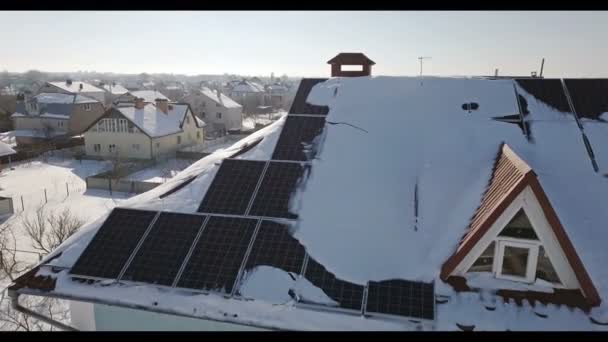 再生可能エネルギー生産モジュール 冬の大雪後の家の屋根の上のソーラー パネル — ストック動画