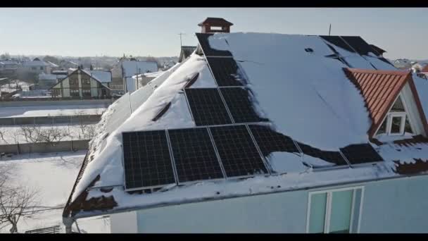 再生可能エネルギー生産モジュール 冬の大雪後の家の屋根の上のソーラー パネル — ストック動画
