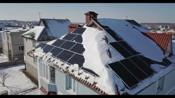 冬の大雪後の家の屋根の上のソーラー パネル 再生可能エネルギー生産モジュール トップ ビュー — ストック動画