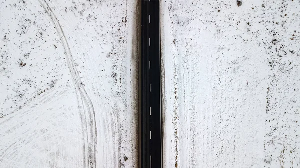 Top view from the air on the winter road in the field on which cars are going — Stock Photo, Image