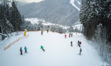 Kayakçı ve snowboard düşkünleri bir kayak merkezinde Bukovel, Ukrayna yamaç aşağı git