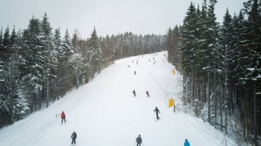 Kayakçı ve snowboard düşkünleri bir kayak merkezinde Bukovel, Ukrayna yamaç aşağı git