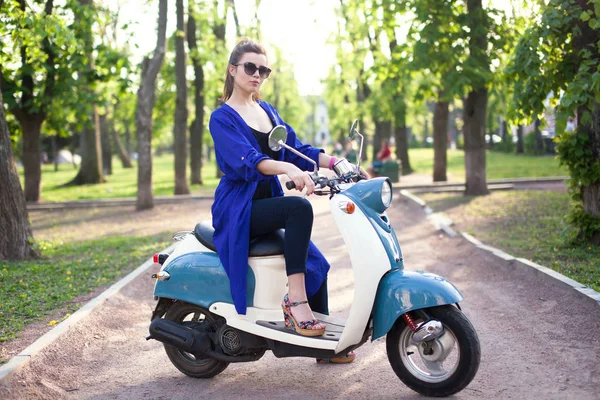 Молодая девушка в винтажном платье сидит на ретро скутере — стоковое фото