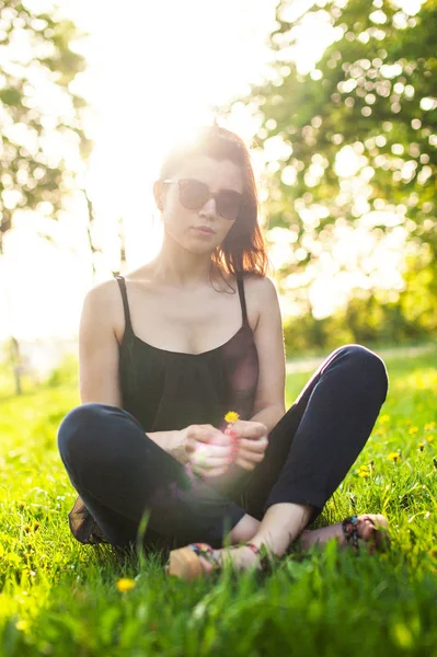 En ung flicka ser på kameran medan promenader i parken — Stockfoto