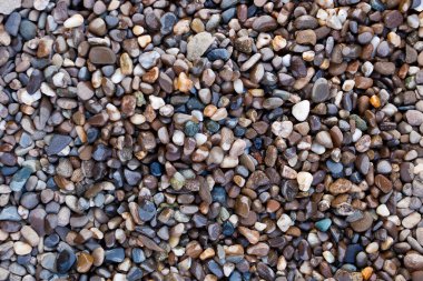 Deniz kıyısında küçük taşlar kapanıyor..