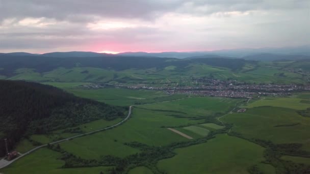 夕日を背景に道路や村とタトラ山脈の空中ビュー — ストック動画