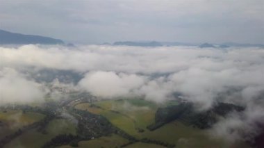 Alçak Tatra 'daki sisli havada sabah dağları manzarası ve arka planda şehir