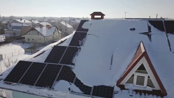 冬の大雪の後 家の屋根の上に太陽光パネルの空中ビュー 再生可能エネルギー生産モジュール — ストック動画