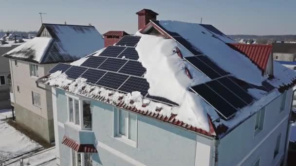 冬の大雪の後 家の屋根の上に太陽光パネルの空中ビュー 再生可能エネルギー生産モジュール — ストック動画