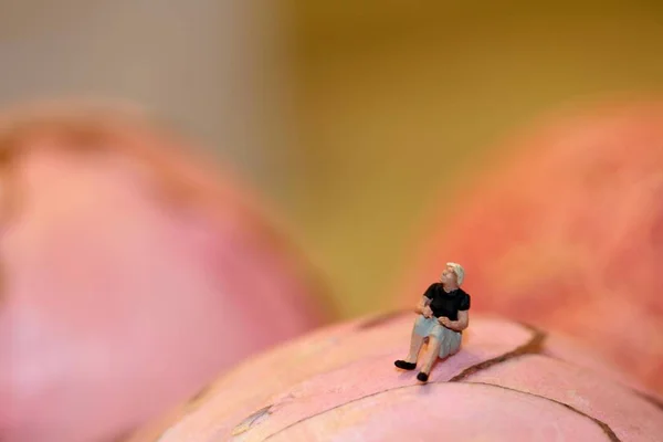 Figurine Miniature Une Femme Seule Assise Sur Fond Rose Abstrait — Photo