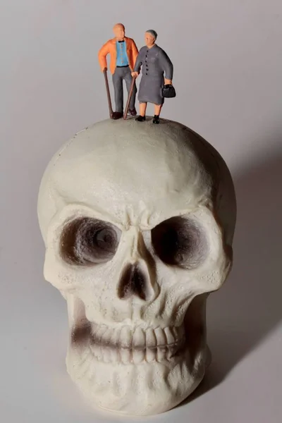 Miniatura Pessoas Idosas Com Crânio Humano Gigante — Fotografia de Stock
