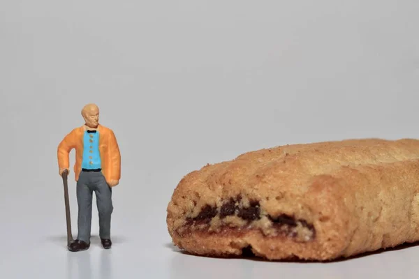 old man with a giant biscuit - diabetes concept